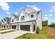 New townhome exterior with white siding, a black garage door, and a well-manicured lawn at 212 Starr Cir, Stockbridge, GA 30281