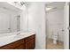 Well-lit bathroom with a wooden vanity, sink, toilet, and a shower/tub combo for everyday use at 325 Cranbrooke Cir, Suwanee, GA 30024