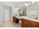 Bright bathroom featuring dual sinks, wood cabinets, and large mirror at 325 Cranbrooke Cir, Suwanee, GA 30024