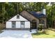 Beautiful home with stone and white facade, arched entryway, and a well-kept lawn in a wooded setting at 3563 Brenda Ct, Douglasville, GA 30135