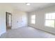 Neutral bedroom with carpeted floor, white walls, two windows, and doors at 3877 Lake Sanctuary Way, Atlanta, GA 30349