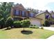 Charming two-story home with a manicured lawn and two car garage at 3877 Lake Sanctuary Way, Atlanta, GA 30349