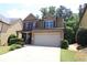 Charming two-story home with a manicured lawn and two car garage at 3877 Lake Sanctuary Way, Atlanta, GA 30349
