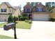 Charming two-story home with a manicured lawn and two car garage at 3877 Lake Sanctuary Way, Atlanta, GA 30349