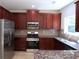Kitchen featuring stainless appliances, cherry cabinets, and granite countertops at 3877 Lake Sanctuary Way, Atlanta, GA 30349