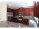 Kitchen featuring stainless appliances, cherry cabinets, and granite countertops at 3877 Lake Sanctuary Way, Atlanta, GA 30349