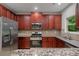 Kitchen with stainless steel appliances, granite countertops, and wooden cabinets at 3877 Lake Sanctuary Way, Atlanta, GA 30349