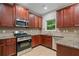 Kitchen with stainless steel appliances, granite countertops, and wooden cabinets at 3877 Lake Sanctuary Way, Atlanta, GA 30349