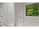 Main bathroom with a soaking tub, walk-in shower, and a view of the trees at 3877 Lake Sanctuary Way, Atlanta, GA 30349