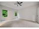 Spacious main bedroom with a tray ceiling, neutral carpet, and large windows at 3877 Lake Sanctuary Way, Atlanta, GA 30349