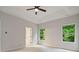 Bright main bedroom with a tray ceiling, ceiling fan, and large windows at 3877 Lake Sanctuary Way, Atlanta, GA 30349