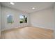 Bright room featuring light wood floors, a window for natural light, and a glass-paneled door at 3877 Lake Sanctuary Way, Atlanta, GA 30349