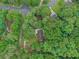 Aerial view of a wooded property featuring a home with a driveway and surrounding greenery at 5259 Sugar Ridge Dr, Sugar Hill, GA 30518
