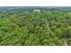 Vast aerial perspective of a home surrounded by lush forestry, creating a tranquil and private oasis at 5259 Sugar Ridge Dr, Sugar Hill, GA 30518