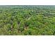 Picturesque aerial view of a home surrounded by a lush green forest, offering a private, wooded setting at 5259 Sugar Ridge Dr, Sugar Hill, GA 30518