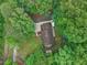 Aerial view of the property shows the home, driveway, carport, and surrounding trees and greenery at 5259 Sugar Ridge Dr, Sugar Hill, GA 30518