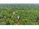 Aerial shot of a home surrounded by a lush green forest, highlighting its peaceful, secluded location at 5259 Sugar Ridge Dr, Sugar Hill, GA 30518