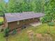 Backyard with a patio, green grass, and mature trees surrounding the property, and a partial view of the house at 5259 Sugar Ridge Dr, Sugar Hill, GA 30518