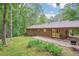 Expansive backyard with lawn, mature trees, and covered patio ideal for relaxation at 5259 Sugar Ridge Dr, Sugar Hill, GA 30518