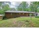 Expansive backyard with lawn, mature trees, and covered patio ideal for relaxation at 5259 Sugar Ridge Dr, Sugar Hill, GA 30518