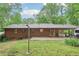 Expansive backyard with lawn, mature trees, and covered patio ideal for relaxation at 5259 Sugar Ridge Dr, Sugar Hill, GA 30518