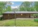 Expansive backyard with lawn, mature trees, and covered patio ideal for relaxation at 5259 Sugar Ridge Dr, Sugar Hill, GA 30518