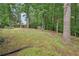 Spacious backyard with lush green grass, mature trees, and a subtle slope, creating a peaceful and private retreat at 5259 Sugar Ridge Dr, Sugar Hill, GA 30518