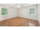 Bedroom featuring hardwood floors, neutral walls, bright windows, and a ceiling fan at 5259 Sugar Ridge Dr, Sugar Hill, GA 30518