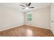Bright bedroom features hardwood floors, a ceiling fan, and a window at 5259 Sugar Ridge Dr, Sugar Hill, GA 30518