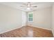 Cozy bedroom with hardwood floors, a ceiling fan, and a bright window at 5259 Sugar Ridge Dr, Sugar Hill, GA 30518