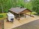 Carport, with a camper parked nearby, next to a home surrounded by trees at 5259 Sugar Ridge Dr, Sugar Hill, GA 30518