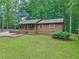 Front view of a single-story home with a well-manicured lawn, mature trees, and charming curb appeal at 5259 Sugar Ridge Dr, Sugar Hill, GA 30518