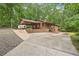 Single-Gathering home with a covered carport and inviting front porch surrounded by trees at 5259 Sugar Ridge Dr, Sugar Hill, GA 30518