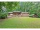 Charming single-Gathering home with a lush green lawn and brown storage shed at 5259 Sugar Ridge Dr, Sugar Hill, GA 30518