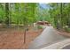 Home on large lot with long driveway with lush green trees on the property line at 5259 Sugar Ridge Dr, Sugar Hill, GA 30518