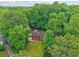 Aerial view of a secluded single-story home surrounded by lush, mature trees and a well-maintained lawn at 5259 Sugar Ridge Dr, Sugar Hill, GA 30518