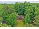 Scenic aerial view of a cozy, single-story home nestled among dense, mature trees, offering privacy at 5259 Sugar Ridge Dr, Sugar Hill, GA 30518
