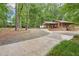 Single-Gathering home with a covered carport and inviting front porch surrounded by trees at 5259 Sugar Ridge Dr, Sugar Hill, GA 30518