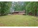 Well-maintained single-Gathering home with a lush green lawn and a brown storage shed at 5259 Sugar Ridge Dr, Sugar Hill, GA 30518