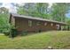 Side view of a charming single-story house surrounded by lush greenery, showcasing a serene and private setting at 5259 Sugar Ridge Dr, Sugar Hill, GA 30518