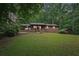 Quaint home with a covered carport and a lush green front yard at 5259 Sugar Ridge Dr, Sugar Hill, GA 30518