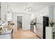 Bright kitchen with stainless steel appliances, granite countertops, and ample white cabinetry and neutral tile flooring at 5259 Sugar Ridge Dr, Sugar Hill, GA 30518