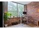 Office space with brick wall, large window, hardwood floors, potted plants, and desk at 800 Peachtree Ne St # 8429, Atlanta, GA 30308