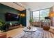 Stylish living room with a brick accent wall, large window, and modern decor at 800 Peachtree Ne St # 8429, Atlanta, GA 30308