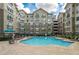 Apartment complex pool with inviting blue water, surrounding lounge chairs and building in the background at 800 Peachtree Ne St # 8429, Atlanta, GA 30308