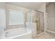 Luxurious bathroom featuring large tub, glass-enclosed shower, and tile flooring at 1867 Castleberry Ln, Buford, GA 30518