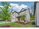 A two-story home with a well-maintained lawn and trees, complimented by stone and siding accents at 1867 Castleberry Ln, Buford, GA 30518