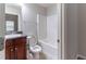Bathroom with shower-tub, dark wood vanity, toilet with elongated bowl, and tile flooring at 204 Saintvry Path, Atlanta, GA 30349