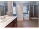 Bathroom with dual showers, soaking tub, and wood vanity at 204 Saintvry Path, Atlanta, GA 30349