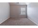 Sunlit bedroom featuring neutral walls, carpet flooring, and a bright window at 204 Saintvry Path, Atlanta, GA 30349